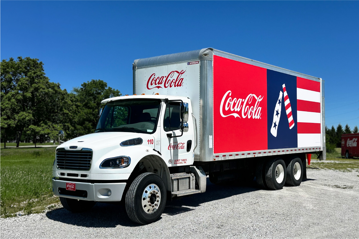 A Coca Cola truck with a patriotic wrap done by Vomela Transportation